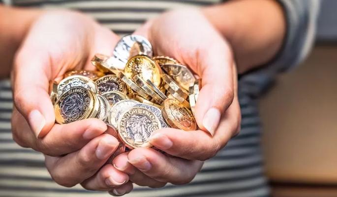 Hands holding pound coins